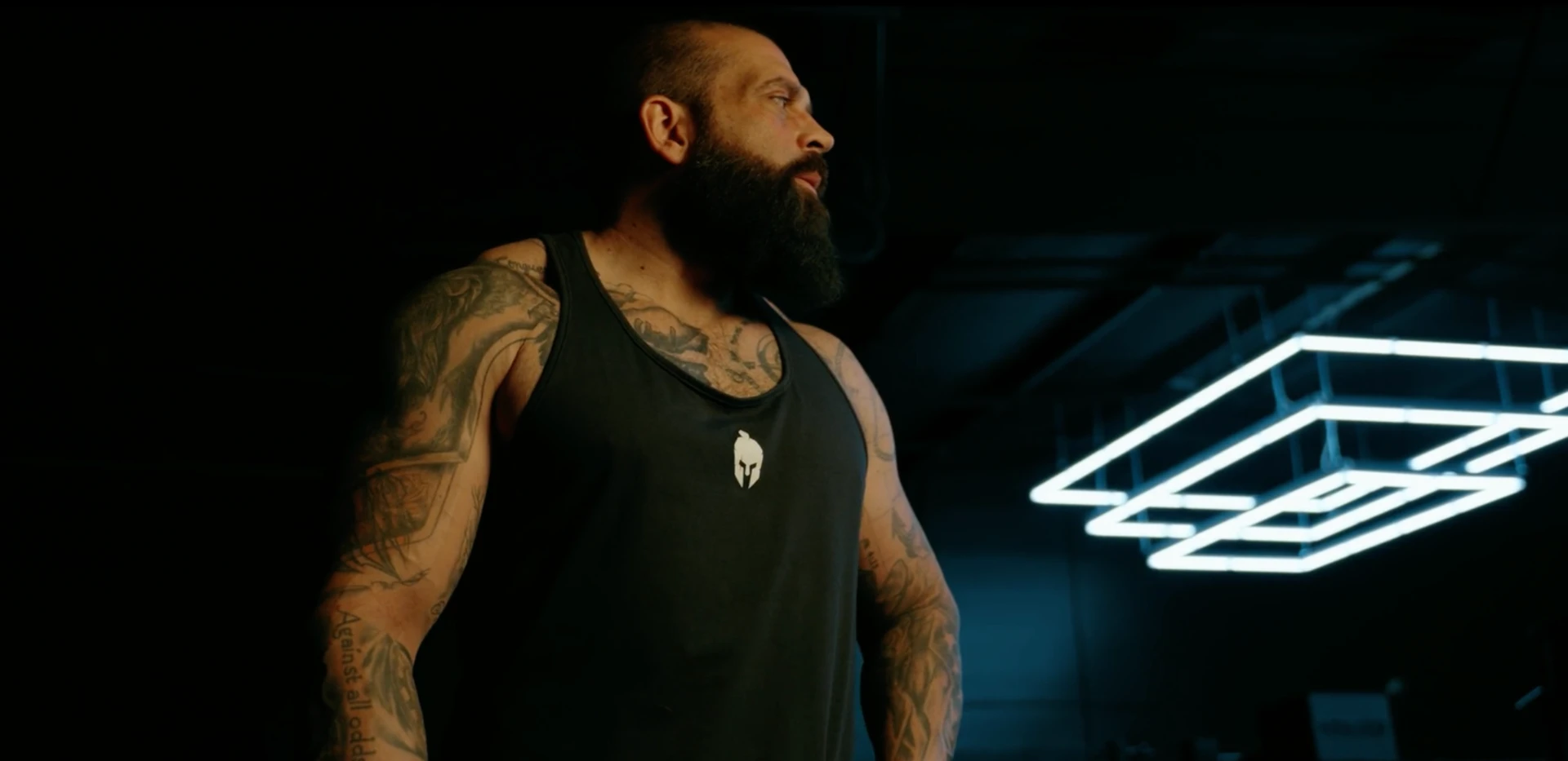 Jeff standing in a dark gym lit by a neon light fixture